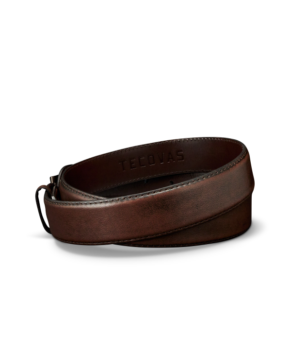 A rolled-up brown leather belt with the word "TECOVAS" embossed on the inside, displayed on a plain white background.