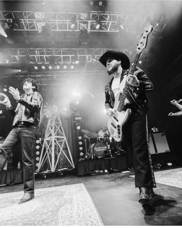 Black and white image of music group playing on a stage