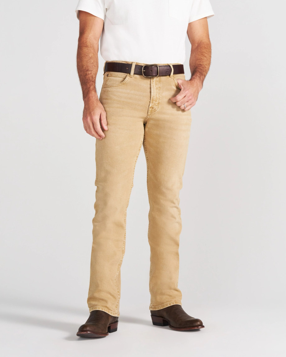 A person wearing a white t-shirt, tan jeans, a brown leather belt, and brown cowboy boots.