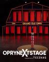 A microphone stands on a branded pedestal on stage at the Grand Ole Opry, with the venue's name illuminated in the background.