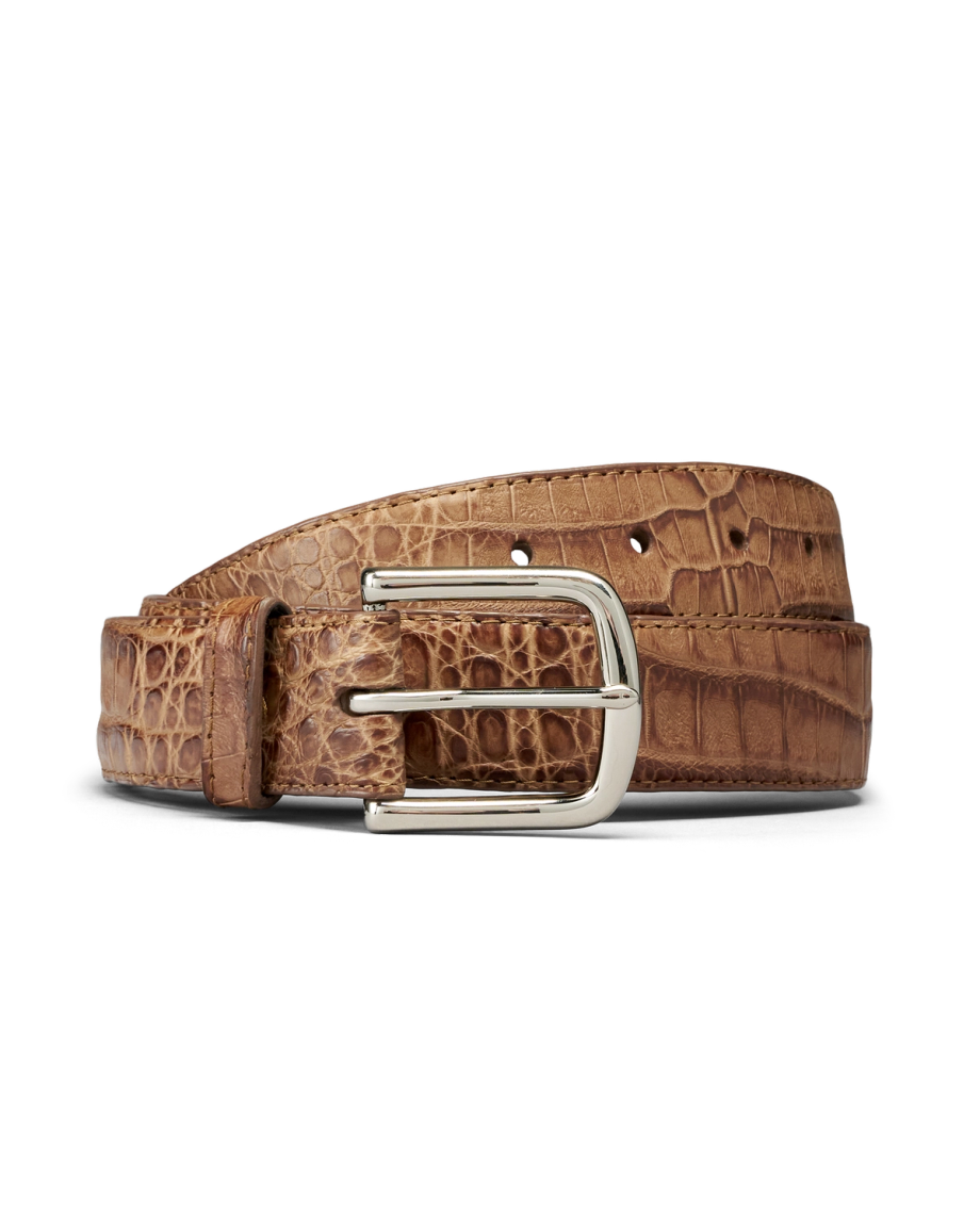 Brown leather belt with a crocodile pattern and a silver rectangular buckle, coiled on a plain white background.