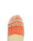A close-up of a beige and orange sock with the partially visible text "TECOV" on the toe, set against a black background.