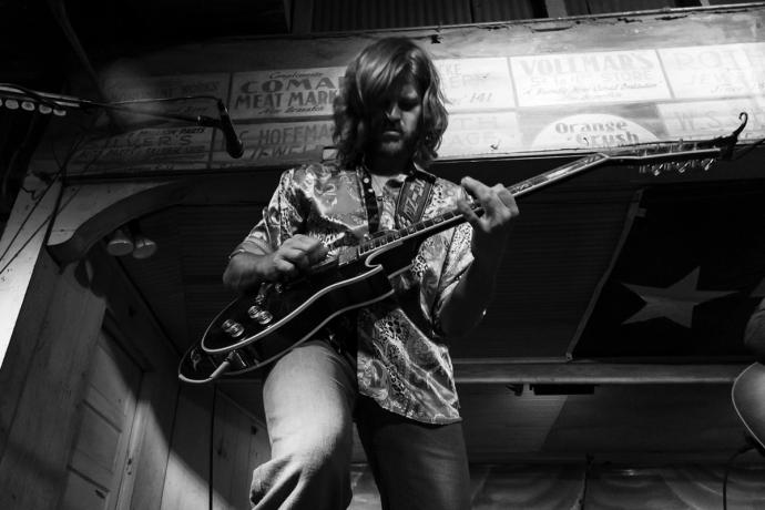 black and white photo of a man playing guitar