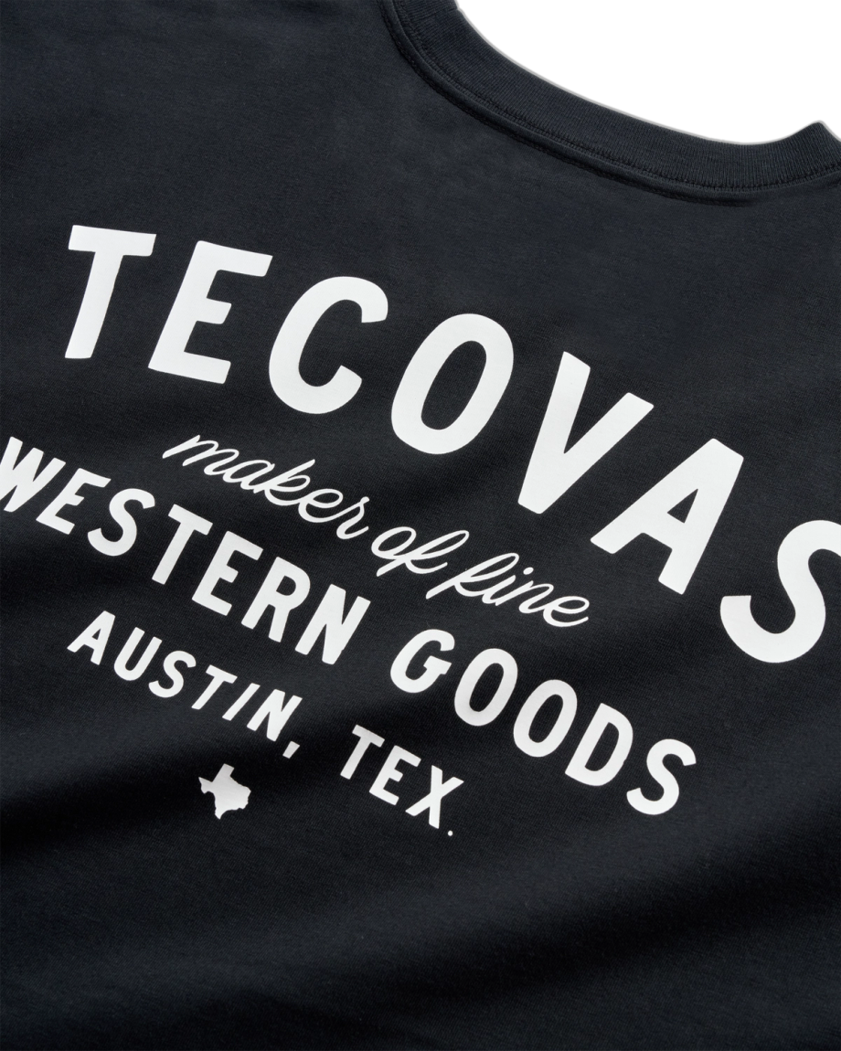 Black T-shirt with white text reading "Tecovas maker of fine Western goods Austin, Tex." and a small Texas silhouette graphic.