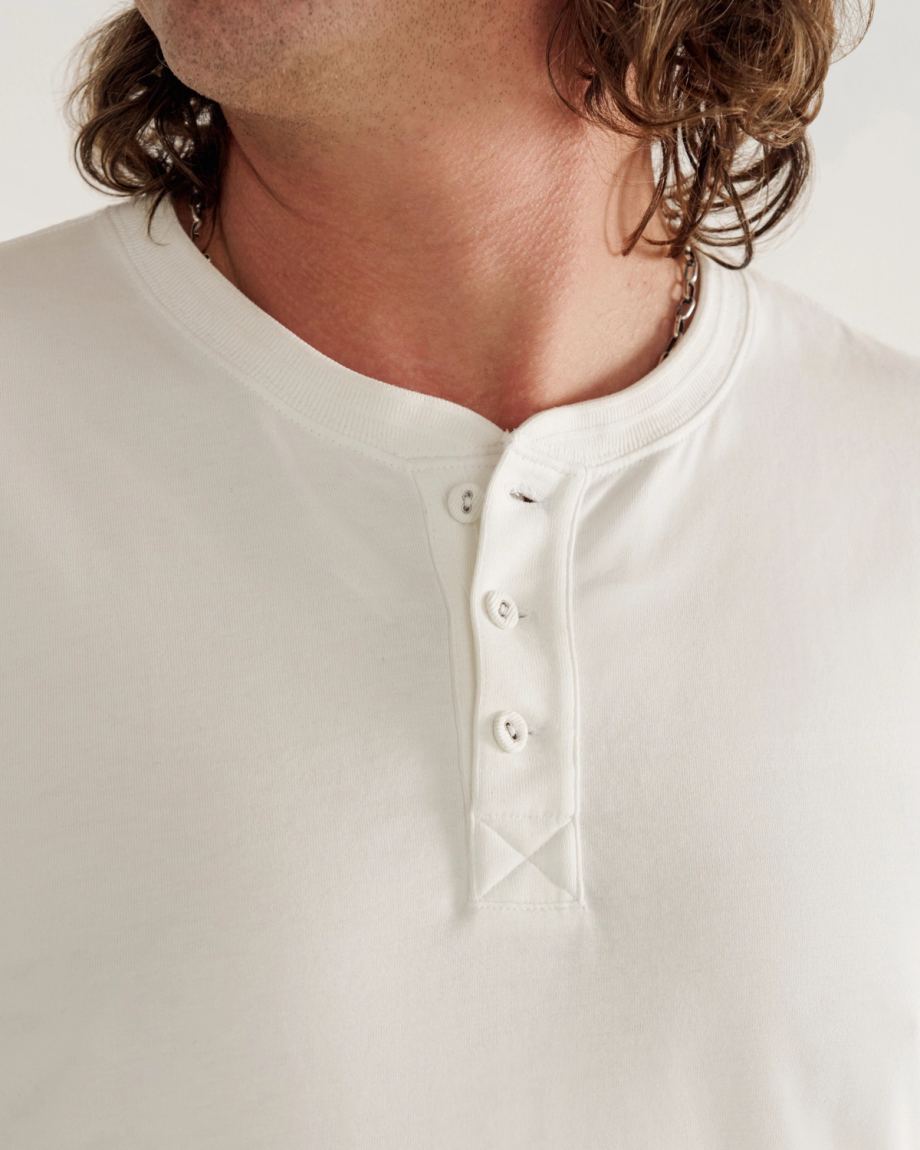 Man wearing a white henley in a photo studio