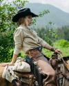 Woman wearing cowboy hat on horseback