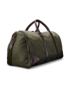 A green canvas and brown leather duffel bag with two handles and a detachable strap sits against a black background.