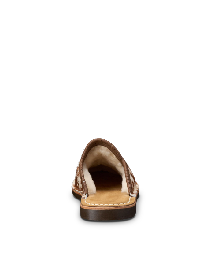 Brown slip-on shoe with fur lining, viewed from the back against a black background.