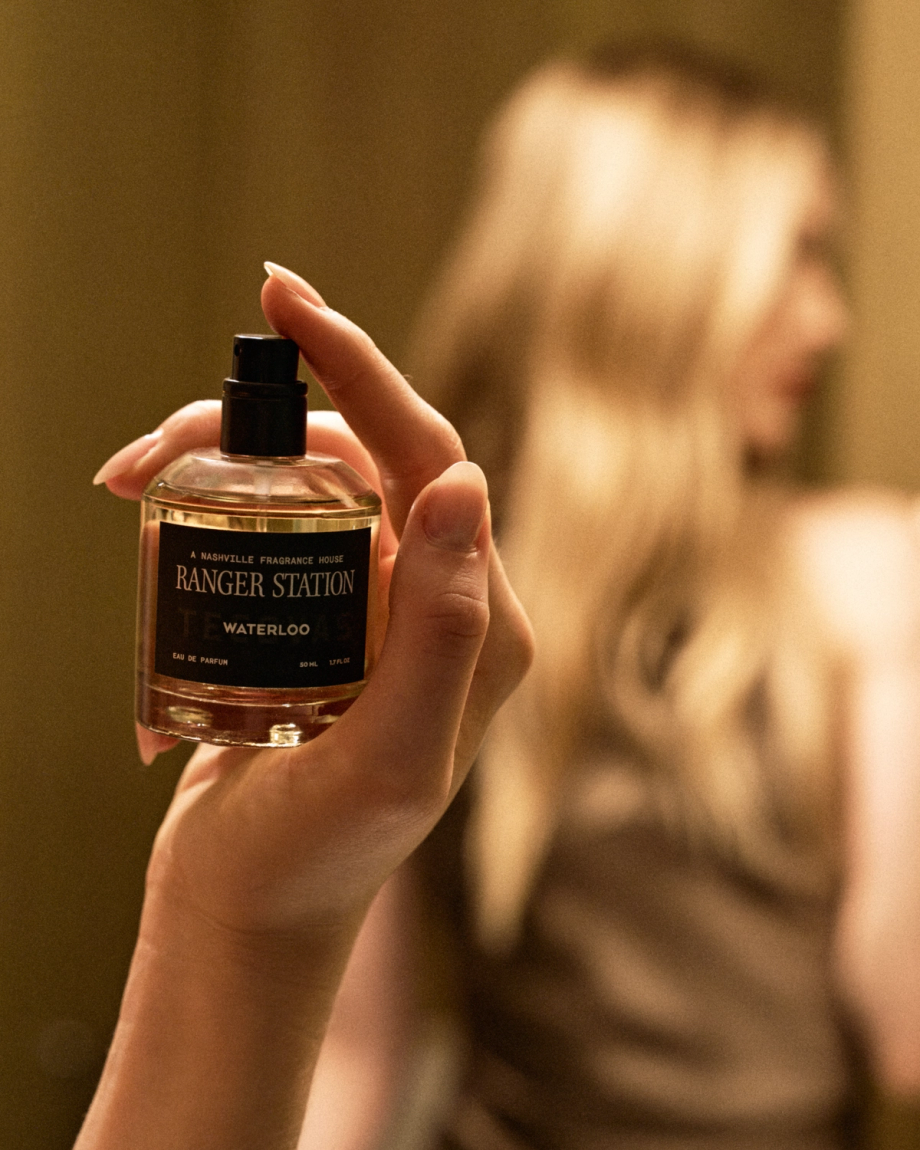 A hand holds a glass bottle of Ranger Station Waterloo eau de parfum.