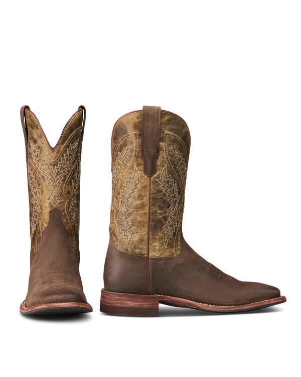 The Doc in Moss Suede. Pair of brown cowboy boots in Moss Suede with intricate stitching, one boot upright showing the side, the other displaying the front.