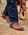 Man on a ranch fence in cowboy boots