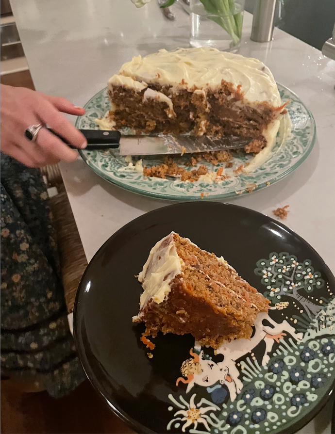 Half of a carrot cake on one plate and a slice of it on another.