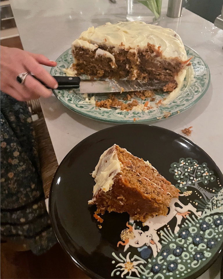 Half of a carrot cake on one plate and a slice of it on another.