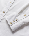 Closeup of the details of a white pearl snap shirt