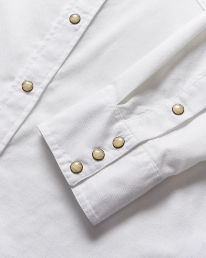 Closeup of the details of a white pearl snap shirt