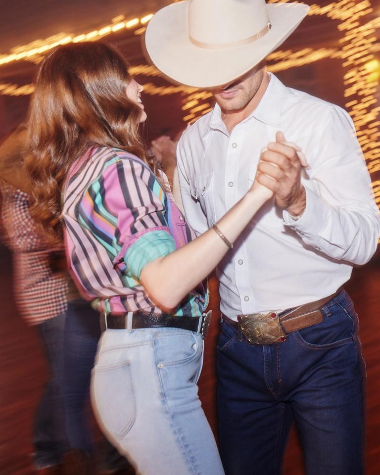 Couple dancing at a dancehall dressed in western attire