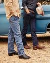 Four men standing in front of a blue pickup truck.