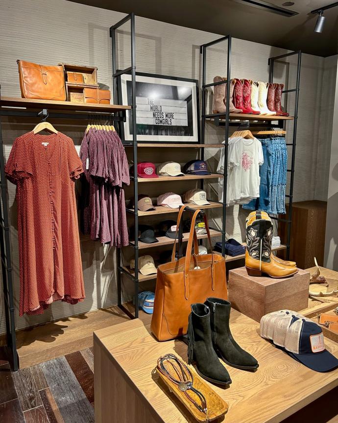 Interior of a boot store with shelves of various styles of western clothing 