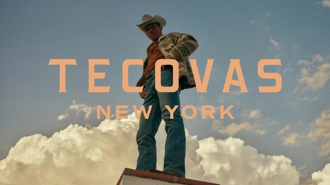 A man in a cowboy hat and boots stands on a rooftop against a cloudy sky. Large text reads "Tecovas New York 105 Wooster.