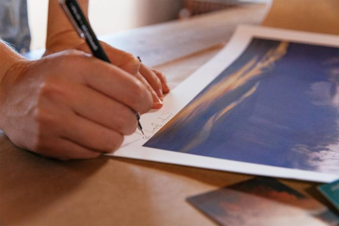 an artist signing their work