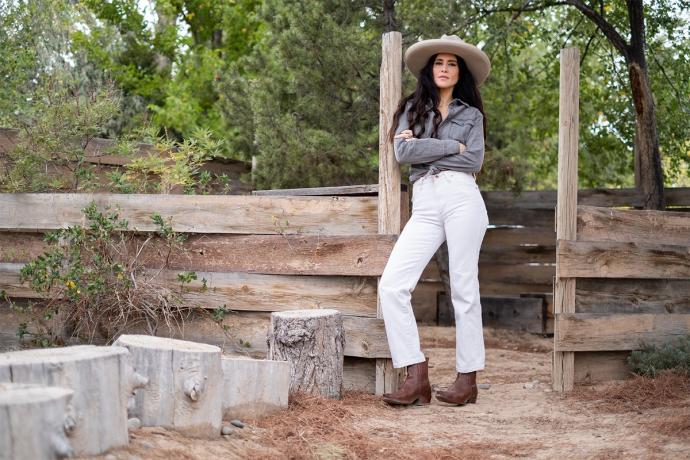 woman standing by a wood fence