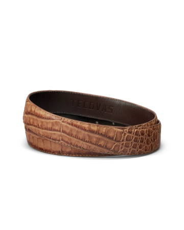 A brown crocodile-embossed leather belt with "Tecovas" stamped on the inner side, displayed coiled on a white background.
