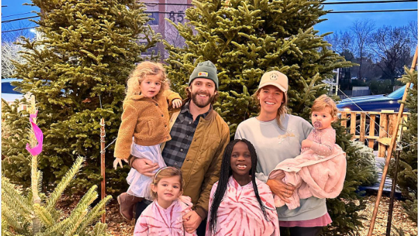 Family standing together by Christmas trees