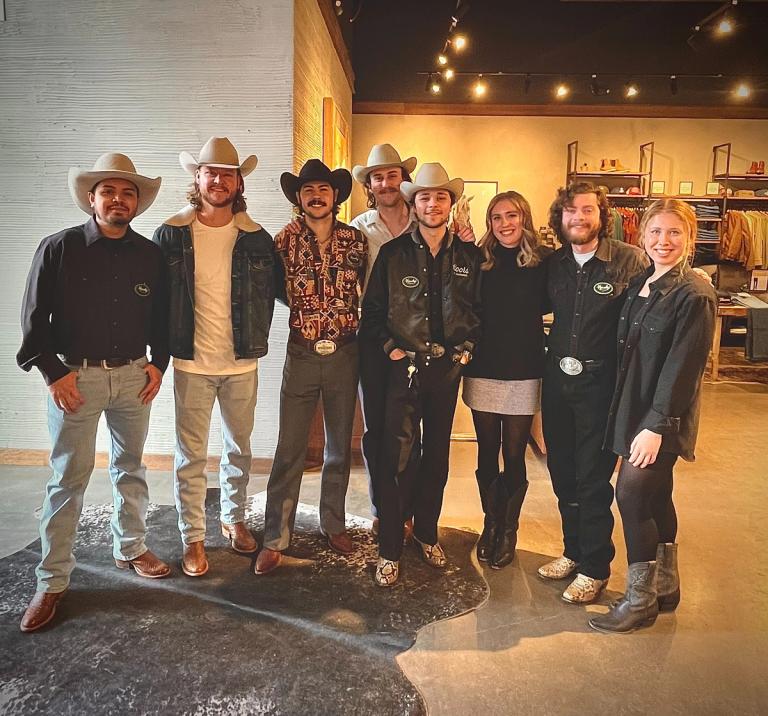 A group of people in cowboy hats posing for a photo.