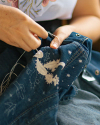 Woman stitching a denim pearl snap