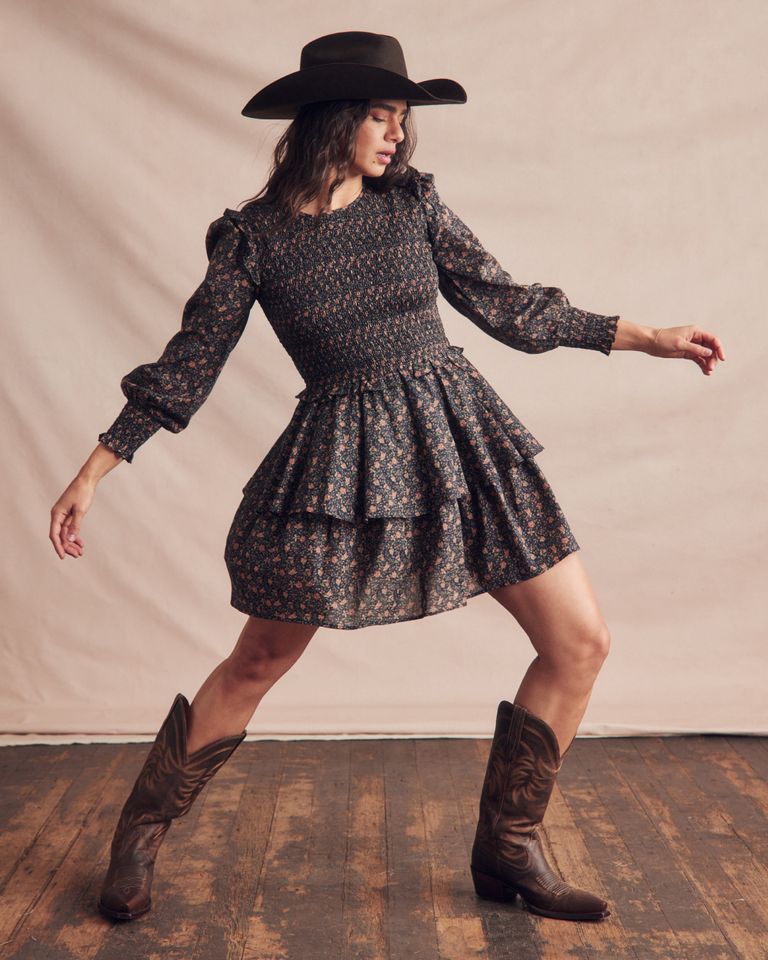 A woman donning a dress and cowboy boots.