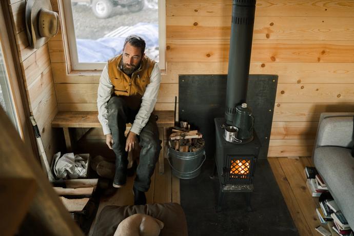 man next to a wood burning stove