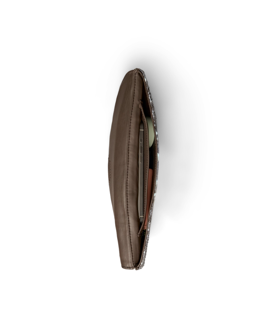 Top-down view of an open dark brown leather clutch containing a smartphone and a small compact.