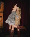 Two women hugging in dresses and boots