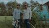 two men in a field with cotton