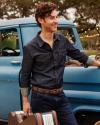 Musician wearing the dark denim pearl snap leaning against a vintage truck