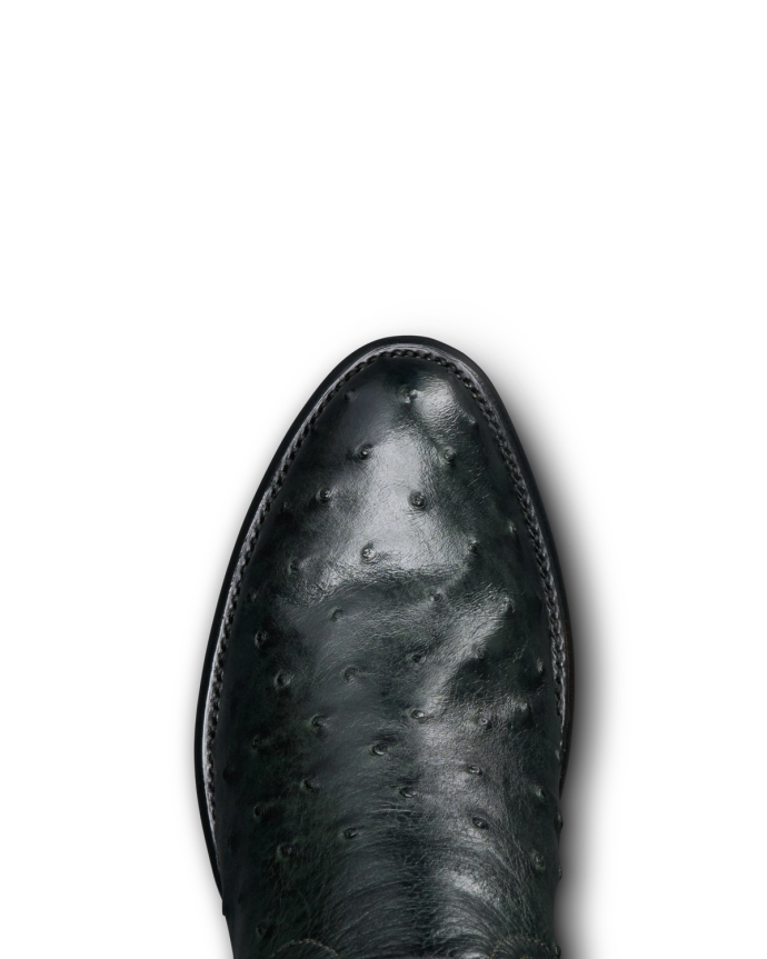 Close-up of a dark-colored, textured leather shoe with visible stitching, set against a black background.