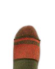 A close-up of a foot wearing a green and red sock with the word "PROVEN" partially visible across the toe area, set against a plain black background.