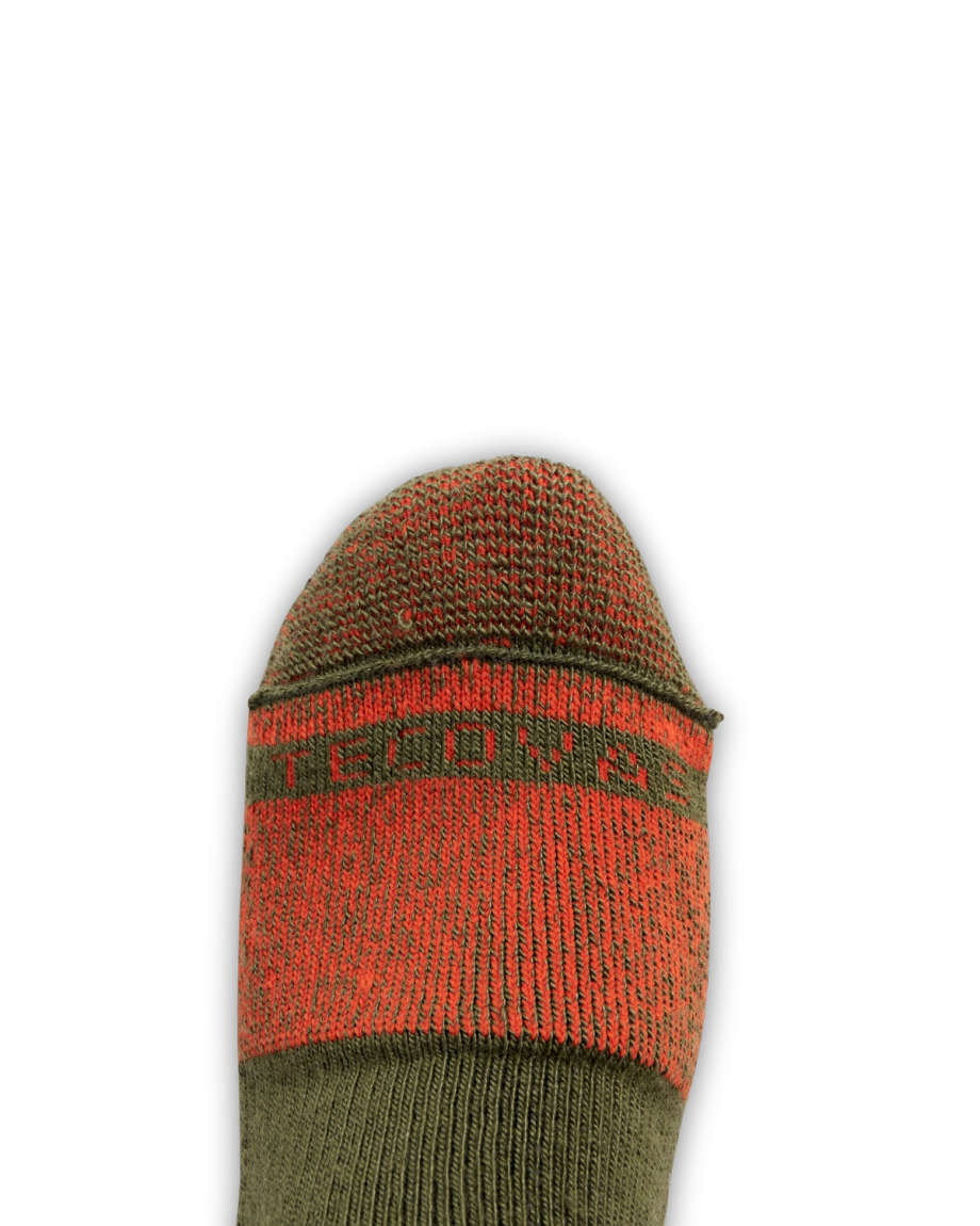 A close-up of a foot wearing a green and red sock with the word "PROVEN" partially visible across the toe area, set against a plain black background.