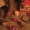 A pair of cowboy boots, a lit candle, wrapped holiday gifts, a red rotary phone, and a dog collar rest on a carpeted floor.
