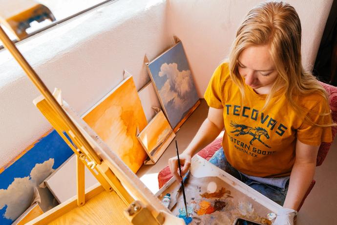 top view of woman painting in a Tecovas tshirt