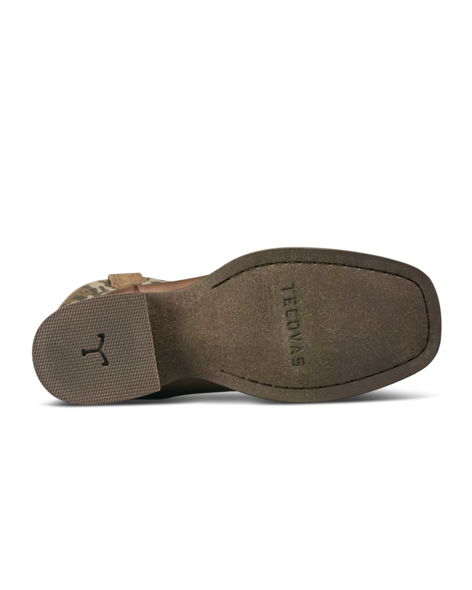 Bottom view of a brown shoe with a textured heel and a grooved marking, “TEJONAS,” stamped on the sole.