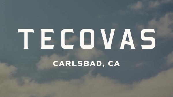 Text reads "Tecovas Carlsbad, CA" in bold white letters against a sky background with scattered clouds.