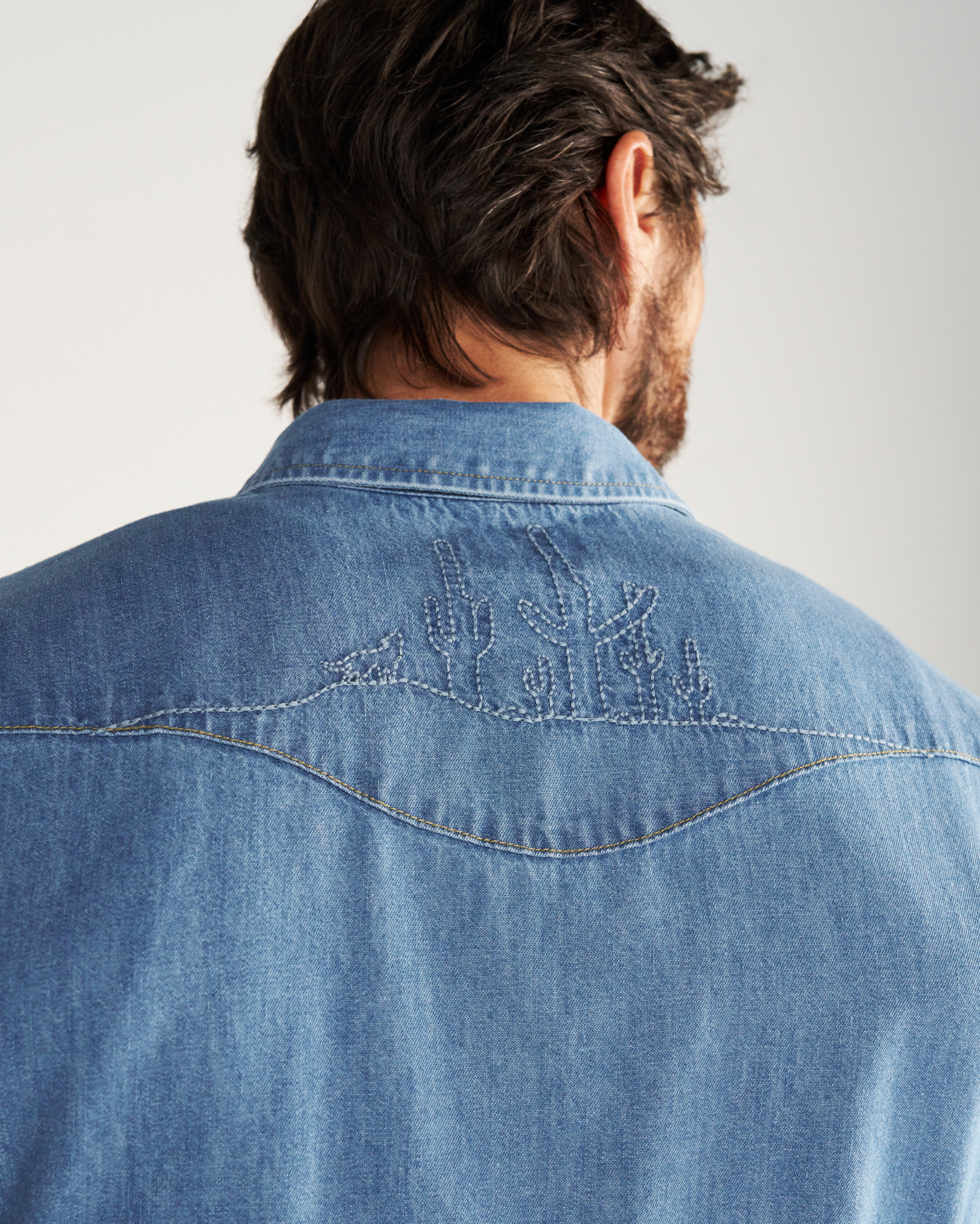 Closeup detail view of Men's Denim Pearl Snap SS - Turquoise / Multi