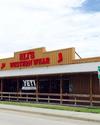 Western-style wear store with a wooden exterior and a sign reading "Eli's Western Wear" on the roof. A large billboard with the same name is visible on the side.