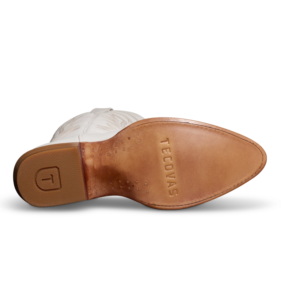 Bottom view of a white cowboy boot with a tan leather sole featuring the brand name "Tecovas" and a rubber heel with a "T" logo.
