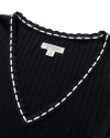 Close-up of a black V-neck ribbed fabric with white crochet trim, featuring a Tecovas label indicating size small.