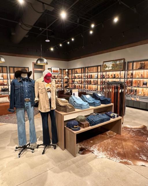 Mannequins dressed in western clothing. Boot wall behind them lined with cowboy boots. 