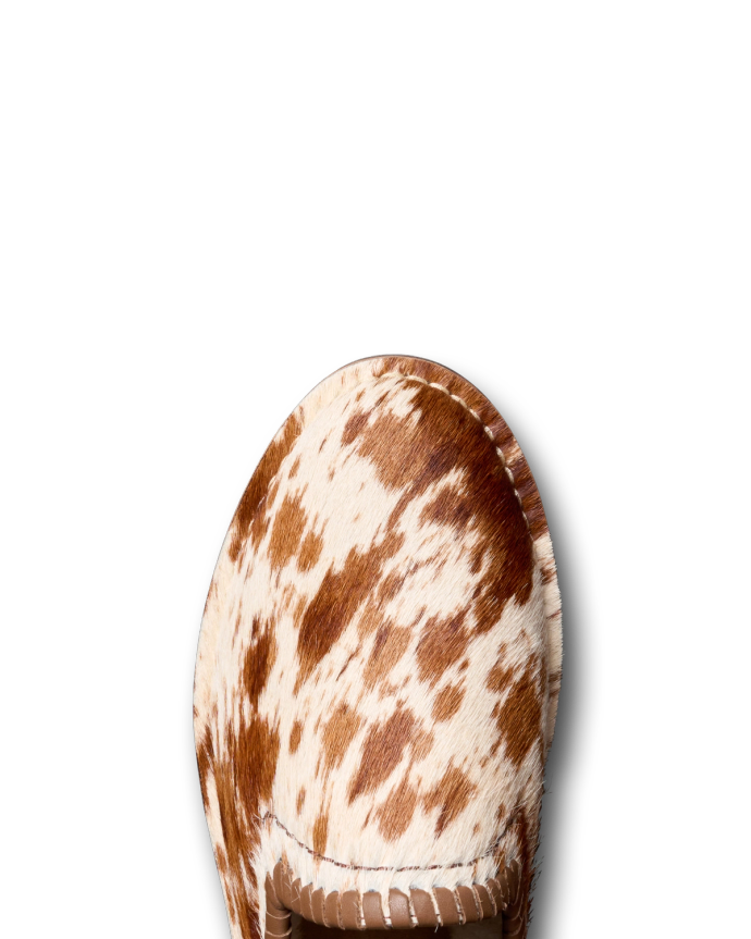 A brown and white speckled pony hair loafer on a black background.