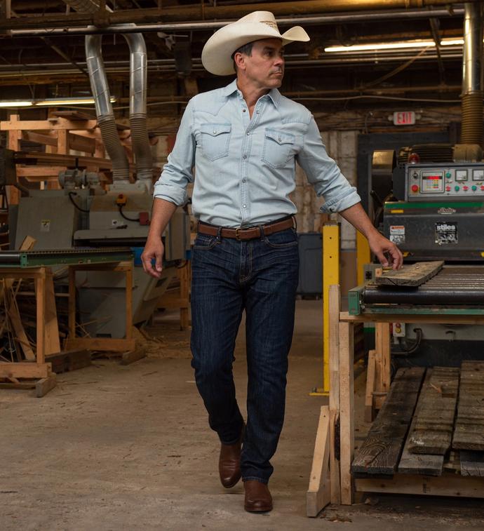Man wearing Chance Chesnut Brown cowboy boots in a workshop