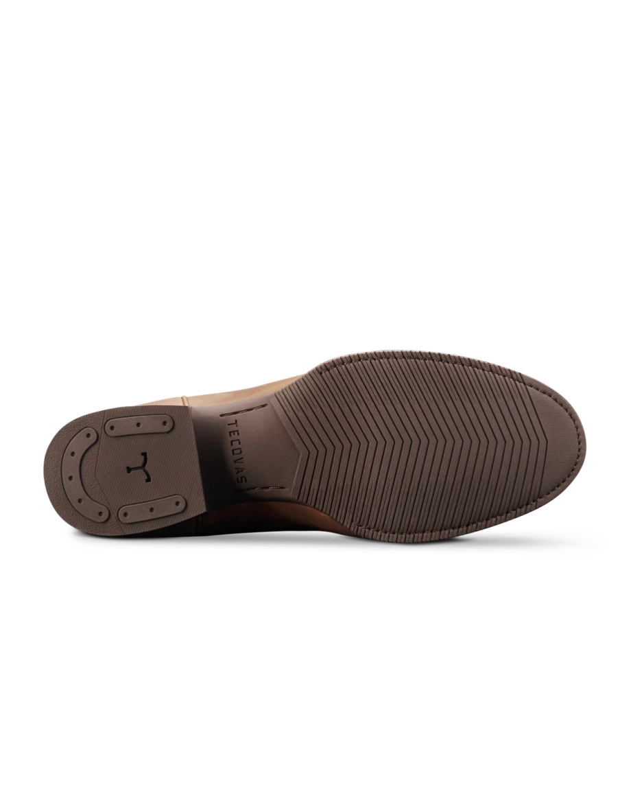 The Glen in Khaki Cowhide. The image shows the brown sole of a dress shoe crafted from premium cowhide, with textured grip patterns and the brand name "Tecovas" engraved in the center.